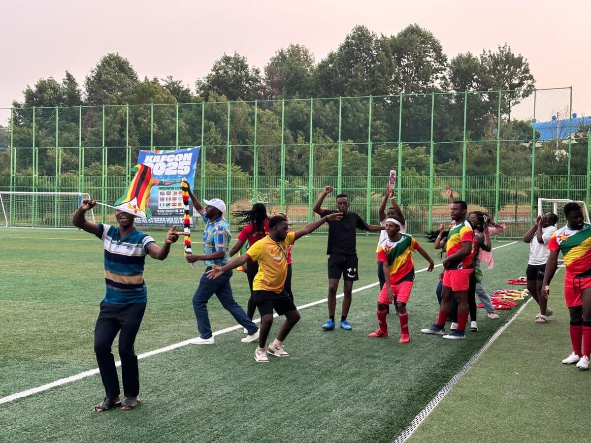 Team Zimbabwe with flags on the pitch at KAFCON